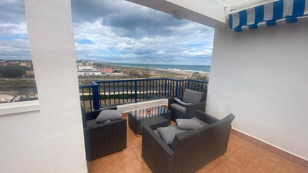 A balcony with wicker furniture and a view of the beach and ocean. - Canal Salinas 1º ático Solo Familias! (Xeraco Playa)