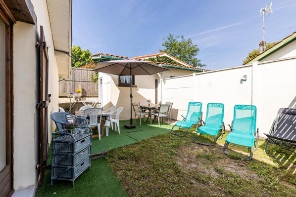Un patio con mobiliario exterior, una mesa y una silla.