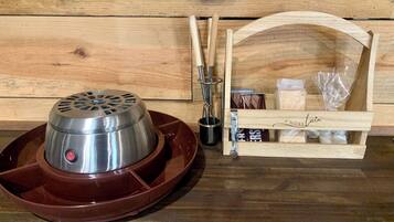 A portable electric heater with a control panel, a wooden tray, a set of chopsticks, a small container, and a wooden box with a label.