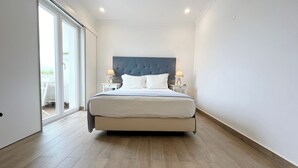 Ein modernes Schlafzimmer mit einem großen Bett, zwei Nachttischen und einer Glastür, die zu einem Außenbereich führt.