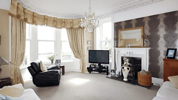 A spacious living room with a fireplace, a television, and a comfortable seating area.