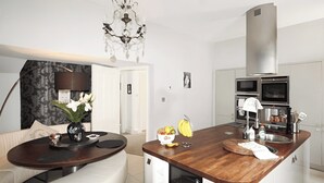 A modern kitchen with a central island, built-in appliances, and a chandelier.