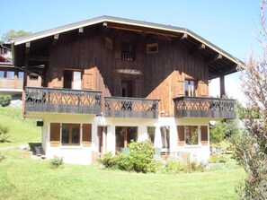 Un chalet in legno con un balcone, un cartello con su scritto 