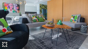 Un salon moderne comprenant un canapé, une table basse et un coin repas avec des chaises.