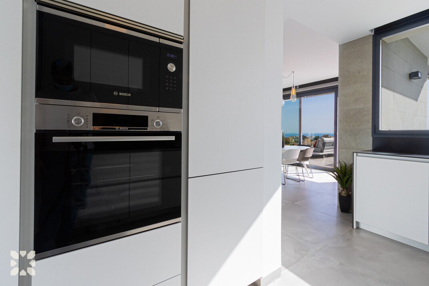 A modern kitchen with a Bosch oven and a view of a balcony with outdoor seating.