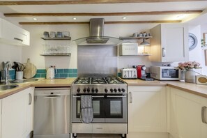 Ovn, oppvaskmaskin, høy barnestol og kjøkkenutstyr