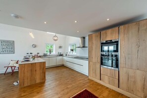 Mikrobølgeovn, ovn, oppvaskmaskin og høy barnestol