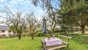 A picnic setup with a table and bench in a grassy area with trees. - 3 Bed in Meshaw (oc-d29056) (Meshaw)
