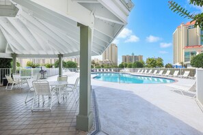 A rooftop pool with lounge chairs and a covered patio area.