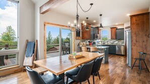 Une cuisine spacieuse dotée de meubles en bois, d’un îlot central et d’un coin repas avec des chaises.