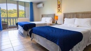 A hotel room with two beds, a balcony, and a view of greenery. - Golden Dream Villas & Studio A/B Poll View (Isabela)