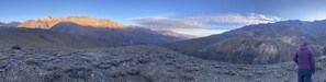 A person standing on a rocky terrain with a mountainous landscape in the background. - Casona El Resguardo (San Esteban)