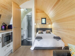 A compact, modern bedroom with a shower, a bed with pillows, a small kitchenette, and a window. - Rabbits Rest - UK46128 (Nesscliffe)