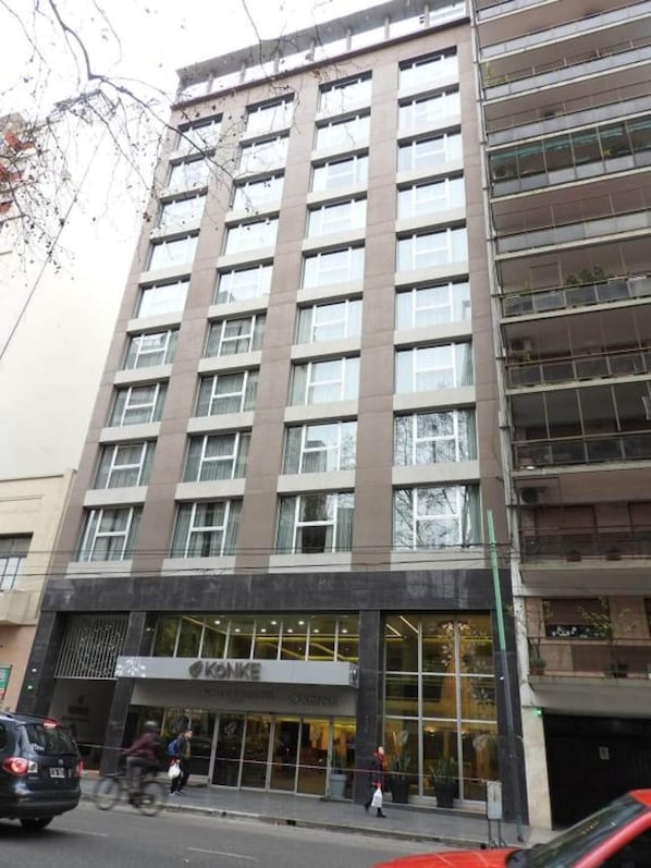 A multi-story building with a modern design, featuring a large glass entrance and a visible store named "KONKE" on the ground floor.