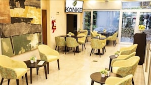 Um saguão de hotel com várias áreas de estar, um extintor de incêndio e uma placa que diz 'KÖNKE'.