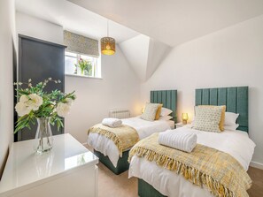 Une chambre moderne avec deux lits, une table de chevet, une fenêtre avec vue et un luminaire suspendu.
