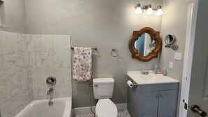 A bathroom with a bathtub, toilet, vanity, and a mirror. - Brand new w/ gorgeous hill views- Ready to relax (Helotes)