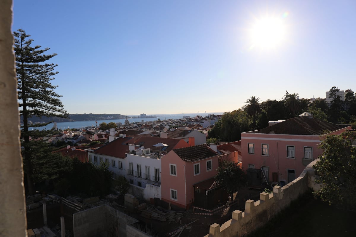 A coastal town with buildings, a clear sky, and a body of water in the distance.