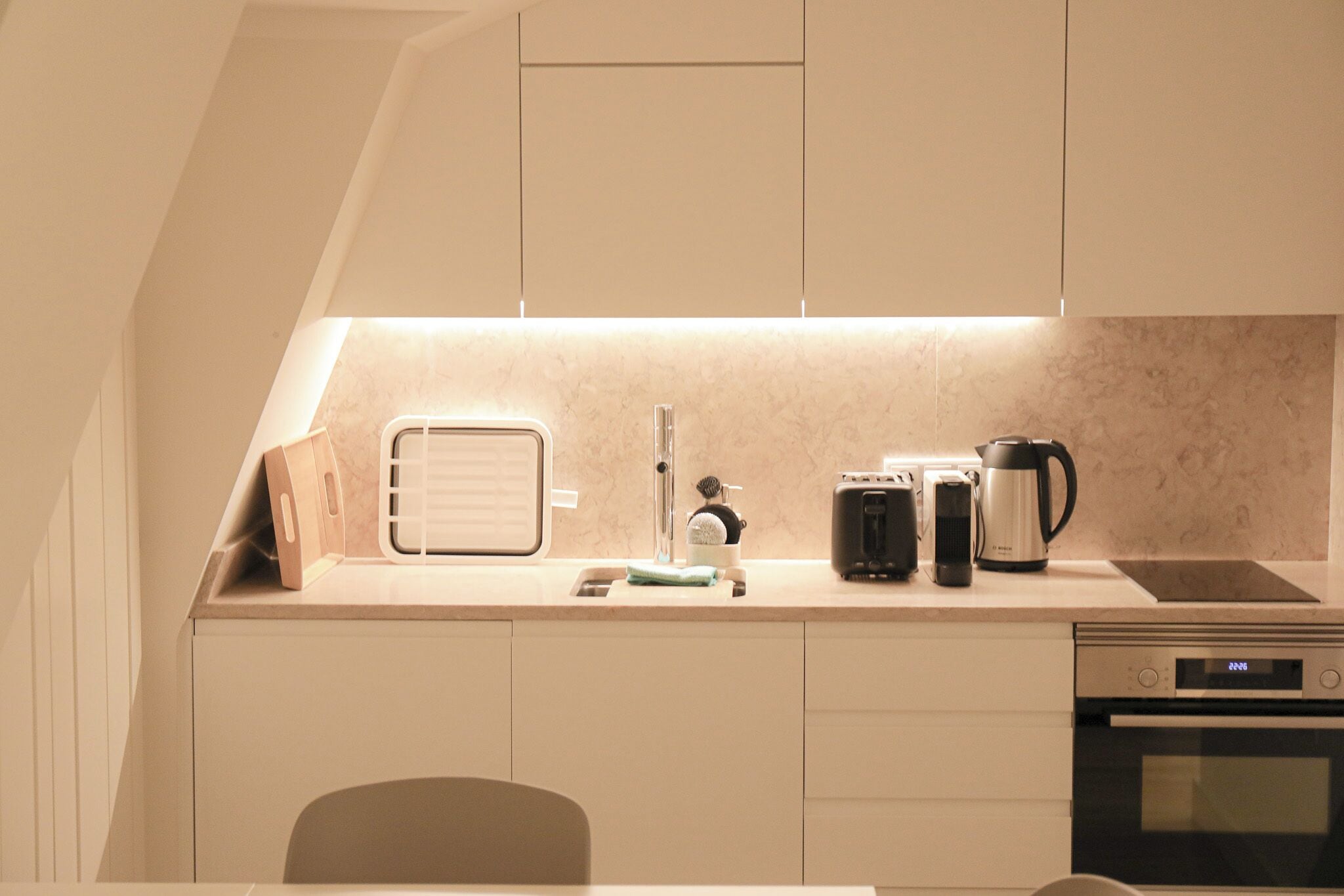A compact kitchen with a built-in oven, a coffee maker, and a toaster.