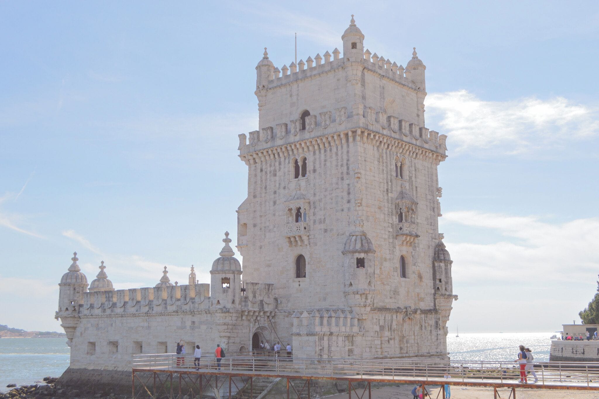 A historic stone fortress with multiple towers and a large central tower, situated by the water.