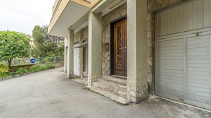 Un bâtiment doté d’une façade en pierre, d’une porte en bois ornée de sculptures complexes et d’une porte de garage.