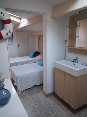 A bedroom with two beds, a bathroom with a sink and mirror, and a skylight above the beds. - Appartement a Bandol a 10 Minutes des Calanques (Bandol)
