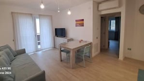 Un salon moderne avec un canapé, une table à manger et un téléviseur.