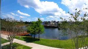 Une vue sur le lac, avec un quai, un pont et des maisons en arrière-plan.