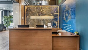 Un mostrador de recepción con un mapa de fondo, una placa que dice "BLUEGREEN VACATIONS" y un panel decorativo en la pared.