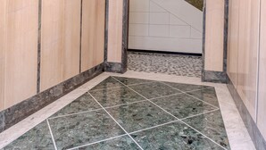A hallway with marble flooring, white and beige walls, and a staircase leading to another floor. - Via Aurelia Levante in Rapallo (Rapallo)