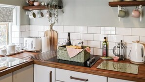 A modern kitchen with white cabinets, a wooden countertop, a stainless steel range hood, and various kitchen appliances. - 2 bedroom accommodation in East Woodburn (East Woodburn)