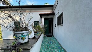 Un estrecho sendero con piso de baldosas que lleva a la entrada de un edificio.