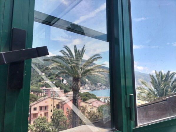 A window with a view of a building and palm trees. - Fantattik loft - private park near the beach -... (Monterosso al Mare)