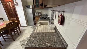 A kitchen with granite countertops, a sink, a stove, and a microwave. - Dora Apartment central location near best beaches (Monterosso al Mare)