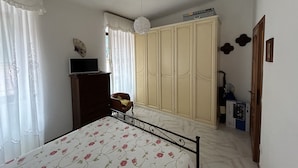 A bedroom with a bed, a wardrobe, a desk, and a chair. - Dora Apartment central location near best beaches (Monterosso al Mare)