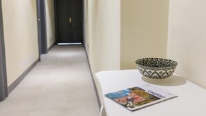 A hallway with a white table, a patterned bowl, and a magazine titled "Cagliari". - Onlyrooms IV - Sea View & Free Parking (Cagliari)
