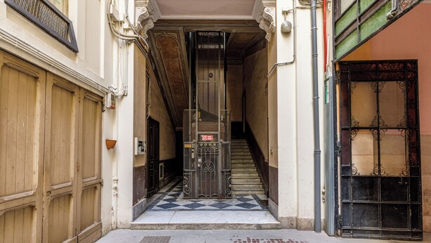 A narrow alleyway with a metal gate, a staircase, and a wooden door. - Onlyrooms IV - Sea View & Free Parking (Cagliari)