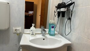 A bathroom with a white sink, a mirror, a hand soap dispenser, and a bottle of blue liquid soap. - VENICE NIGHT 25 DOUBLE ROOM  A (Mestre)