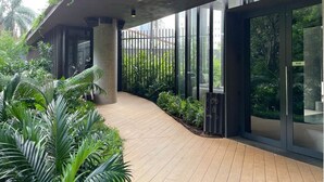 A modern building with a covered walkway, large windows, and lush greenery. - Onze22 NR (São Paulo)