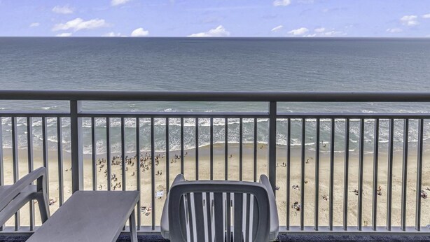 Een balkon met uitzicht op het strand en de zee.