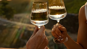 Two people toasting with wine glasses against a sunset backdrop. - Destino Hotel & Hot Springs Day Pass  (Fortuna)