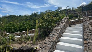 A stone staircase leading up a hill with a view of lush greenery and a clear sky. - Destino Hotel & Hot Springs Day Pass  (Fortuna)