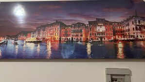 A panoramic view of a historic waterfront cityscape with buildings along the water, illuminated by artificial lighting. - VENICE NIGHT 25 DOUBLE ROOM C (Mestre)