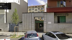 A street view with a building that has a green door and a sign with "IS ITAMO" written on the wall. There are two cars parked in front of the building. - VENICE NIGHT 25 DOUBLE ROOM C (Mestre)