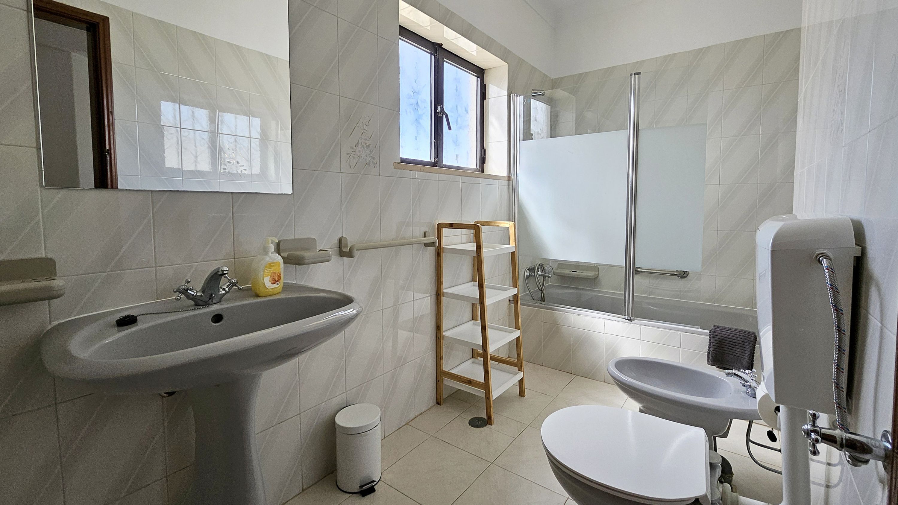 A modern bathroom with a sink, toilet, and shower.