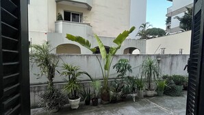 Un patio con plantas en macetas y un edificio con balcones.