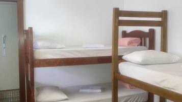 Une chambre avec un lit superposé, dont la structure est en bois et la literie est blanche.