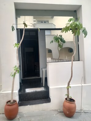 A doorway leading to a covered outdoor area with a small table and a potted plant. - Hostel Paulista (São Paulo)