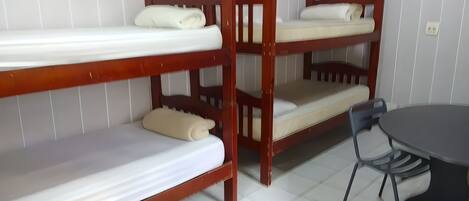 Habitación con literas, una mesa y sillas.