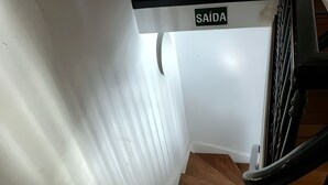 Una escalera de madera con paredes blancas y un letrero que dice "SAÍDA".